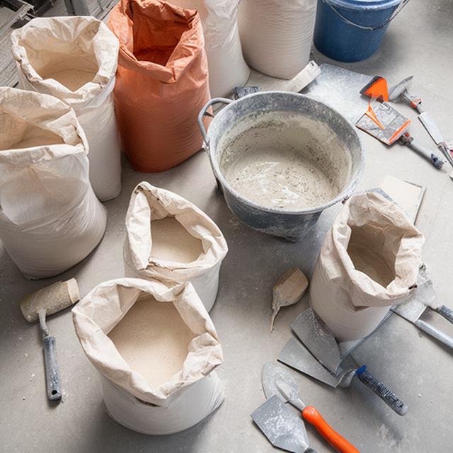 Spezialmörtel in einem Mischwerk mit Säcken und bereitstehendem Werkzeug